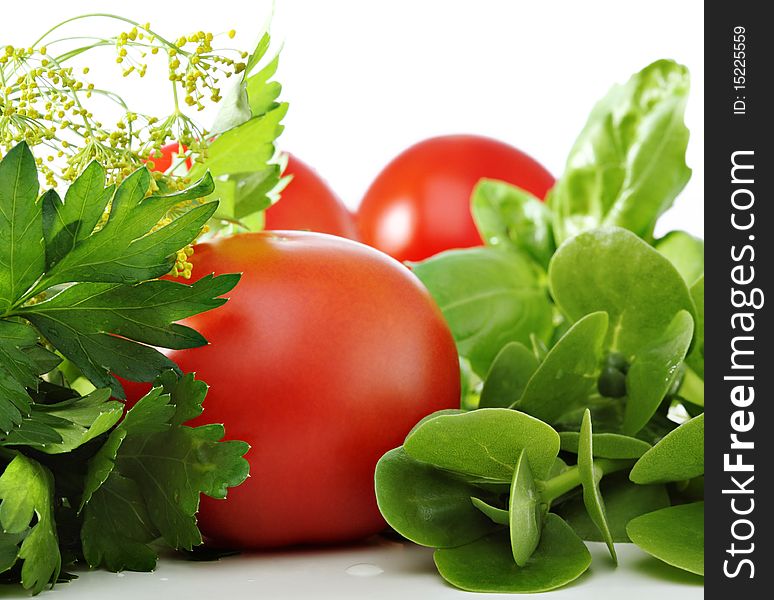 Tomatoes and green herbs on white background. Tomatoes and green herbs on white background