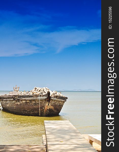 Floating wooden boat under blue sky at Pattaya beach. Floating wooden boat under blue sky at Pattaya beach