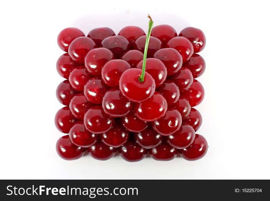 Sour cherries ordered in form of a pyramid top view isolated on white