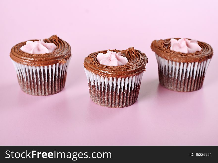 Shot of a raspberry cupcakes on pink