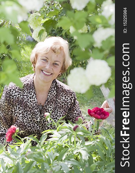 Portrait of relaxed senior woman in a blossoming garden. Portrait of relaxed senior woman in a blossoming garden