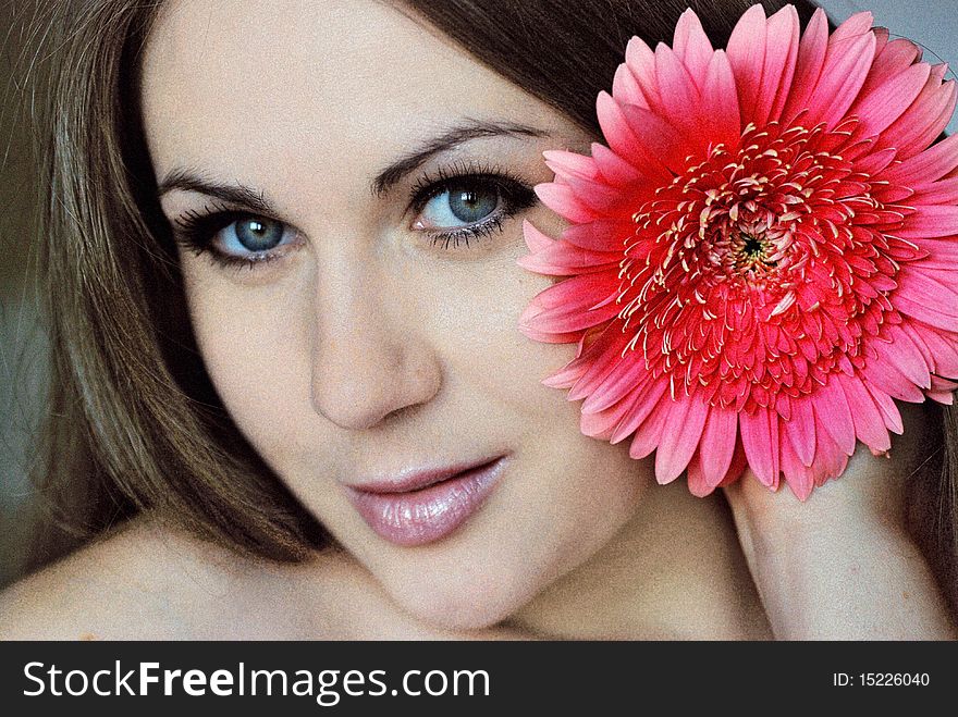 Stylized photo with a grain.Portrait of young woman with flower.