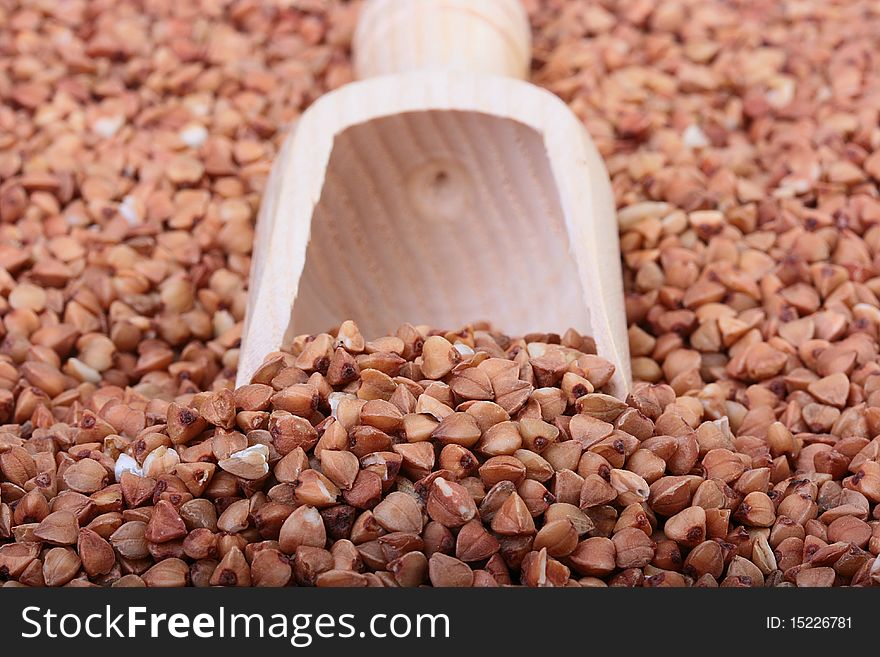 Buckwheat groats with a wooden deep spoon for packaging.