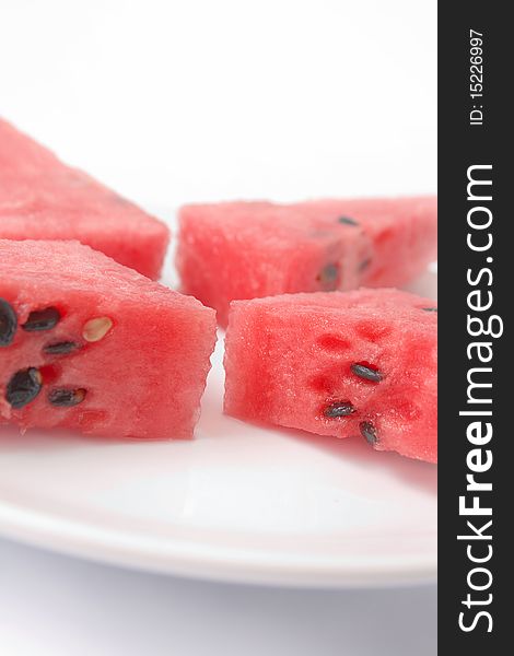 Slices of watermelon portion in plate close up isolated over white bacground