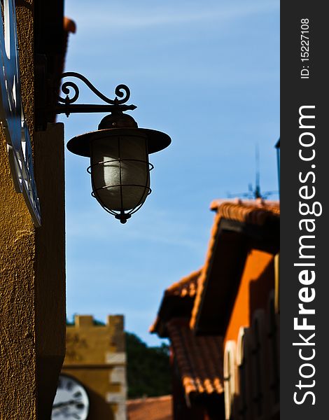 Lantern that setting on wall for giving lighting beside building with blue sky background. Lantern that setting on wall for giving lighting beside building with blue sky background