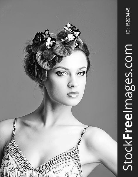 Beautiful girl with a wreath of flowers on her head on the white background