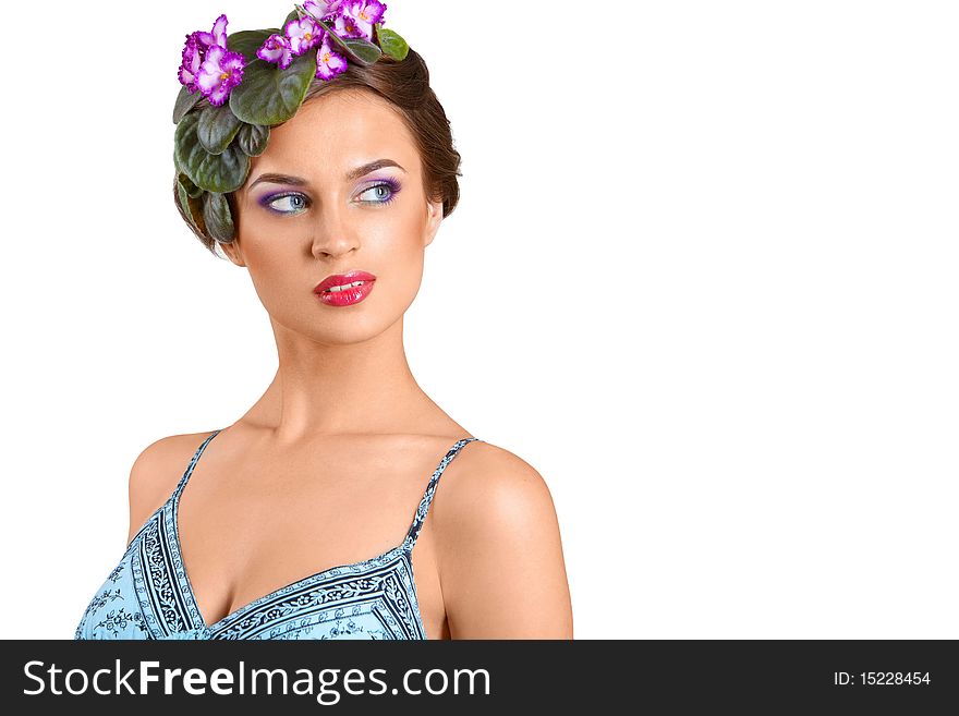 Beautiful girl with a wreath of flowers on her head on the white background