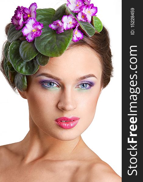 Beautiful girl with a wreath of flowers on her head on the white background
