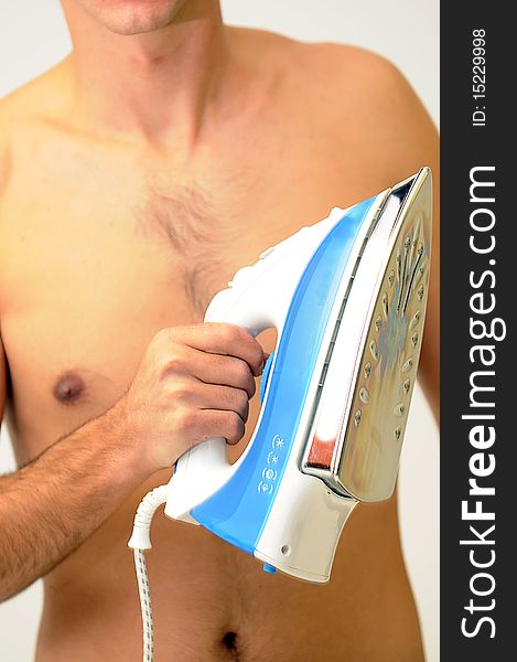 Naked man holding a blue and white clothing iron in front of hairy chest