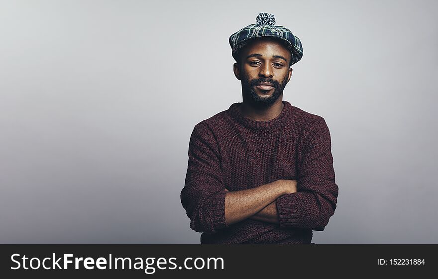 Man in scottish cap isolated on grey background. African american man looking at camera with arms crossed. Man in scottish cap isolated on grey background. African american man looking at camera with arms crossed