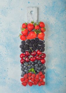 Fresh Organic Summer Berries Mix On White Marble Board On Blue Kitchen Table Background. Raspberries, Strawberries, Blueberries, Royalty Free Stock Image