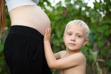 Little Blond Boy Strokes The Belly Of His Pregnant Mother. Family Concept Royalty Free Stock Photography