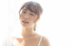Portrait Of Beautiful Young Asian Woman Standing The Window And Smile While Wake Up With Sunrise At Morning Stock Images