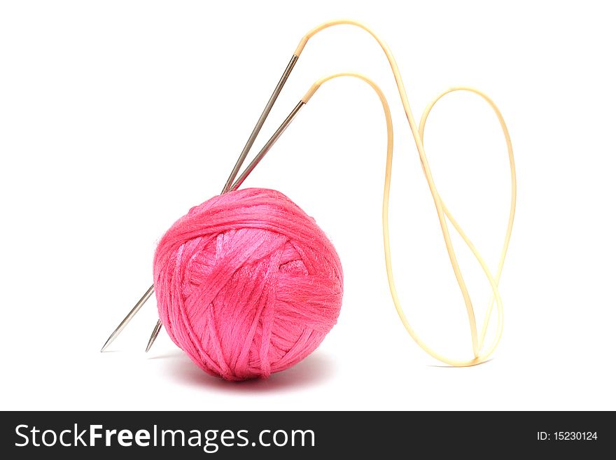 Pink clew and knitting needles isolated on white