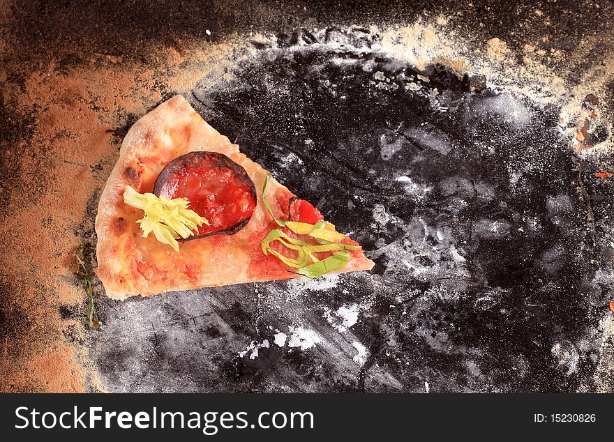 Slice of freshly baked pizza on a baking tin