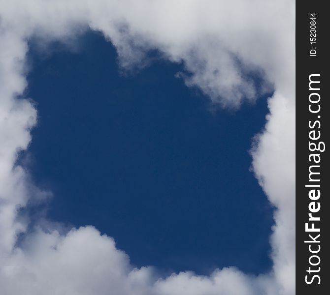 An image of a blue sky with clouds forming a frame. An image of a blue sky with clouds forming a frame