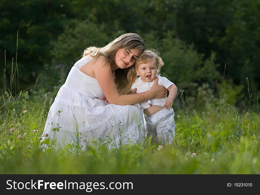 A young attractive woman holds her little cute baby in his hands. A young attractive woman holds her little cute baby in his hands