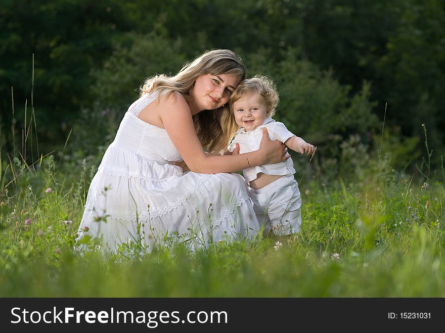 A young attractive woman holds her little cute baby in his hands. A young attractive woman holds her little cute baby in his hands