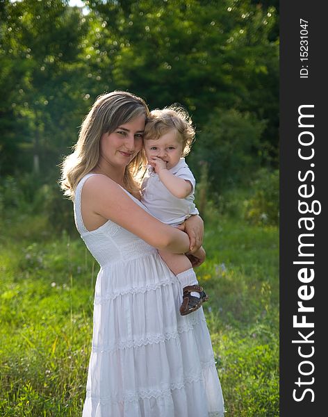 A young attractive woman holds her little cute baby in his hands. A young attractive woman holds her little cute baby in his hands