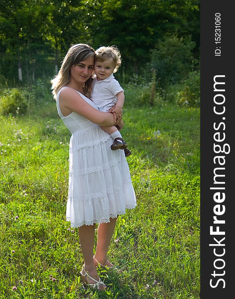 A young attractive woman holds her little cute baby in his hands. A young attractive woman holds her little cute baby in his hands