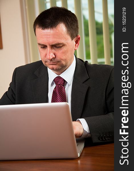 Successful businessman working on a laptop in the office. Successful businessman working on a laptop in the office