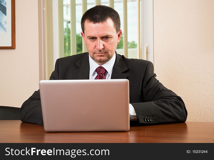 Successful businessman working on a laptop in the office. Successful businessman working on a laptop in the office