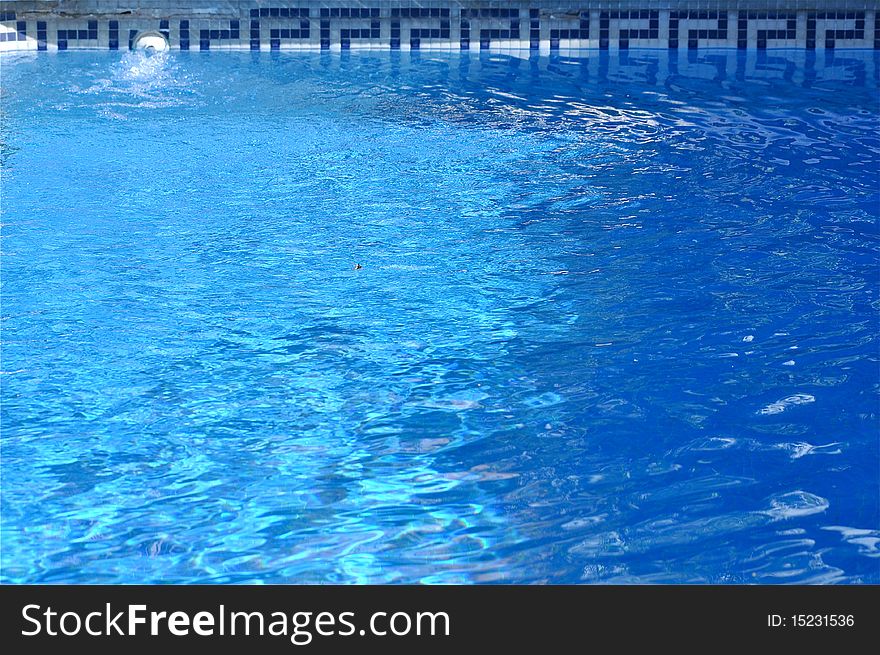 Background of water. It is a swimming pool with a beautiful border design.