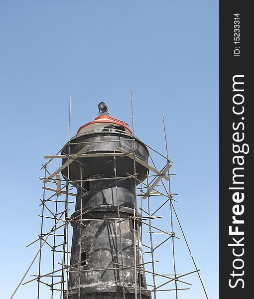 Scaffolding around a lighthouse tower. Scaffolding around a lighthouse tower