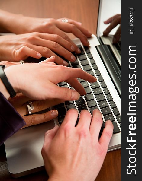 Hands of three business women workingon laptop in the office. Hands of three business women workingon laptop in the office