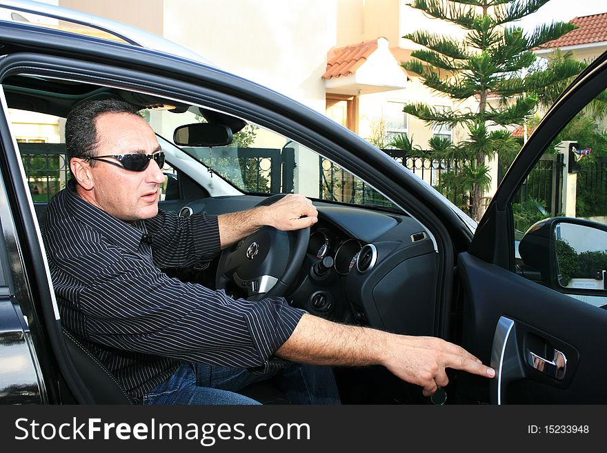 Man in new black car. Man in new black car.