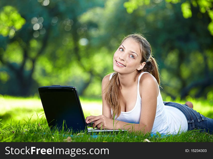 Thoughtful girl with a laptop in the park. Thoughtful girl with a laptop in the park