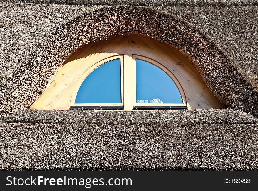 Wooden window on the straw roof