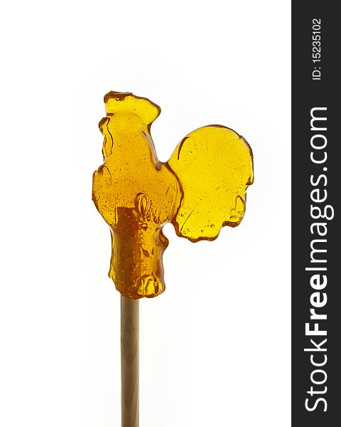 Caramel in the form of chicken on sticks in front of white background
