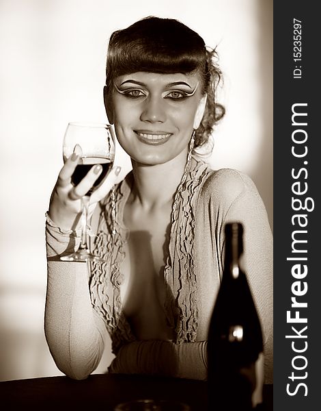 Cheerful girl with wineglass at table