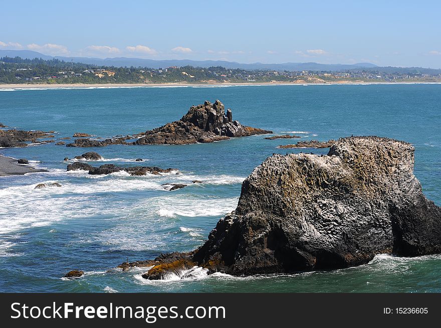 Large sea rocks with birds on them right on the oregon coast line.