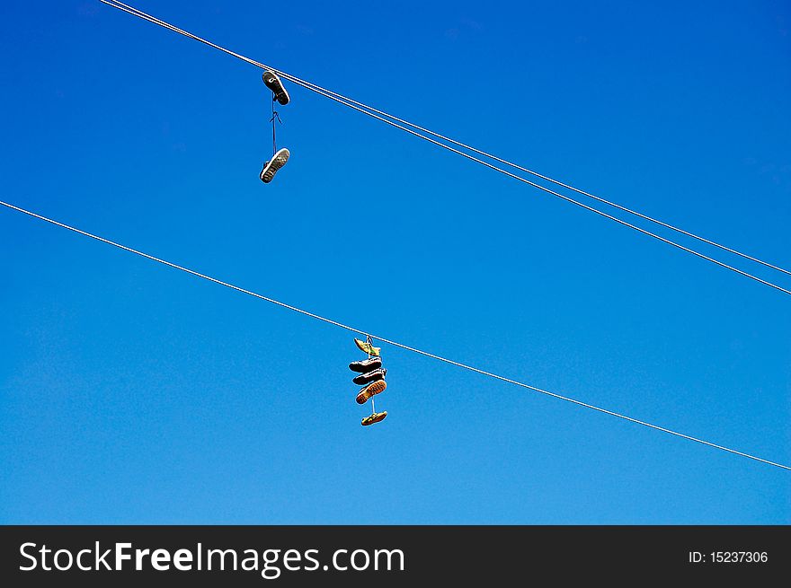Shoes hanging high on wire. Shoes hanging high on wire