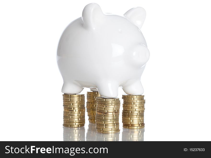 Piggy Bank standing on some stack of coins - isolated on a white backgorund