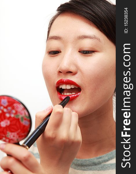 Attractive young lady applying lipstick