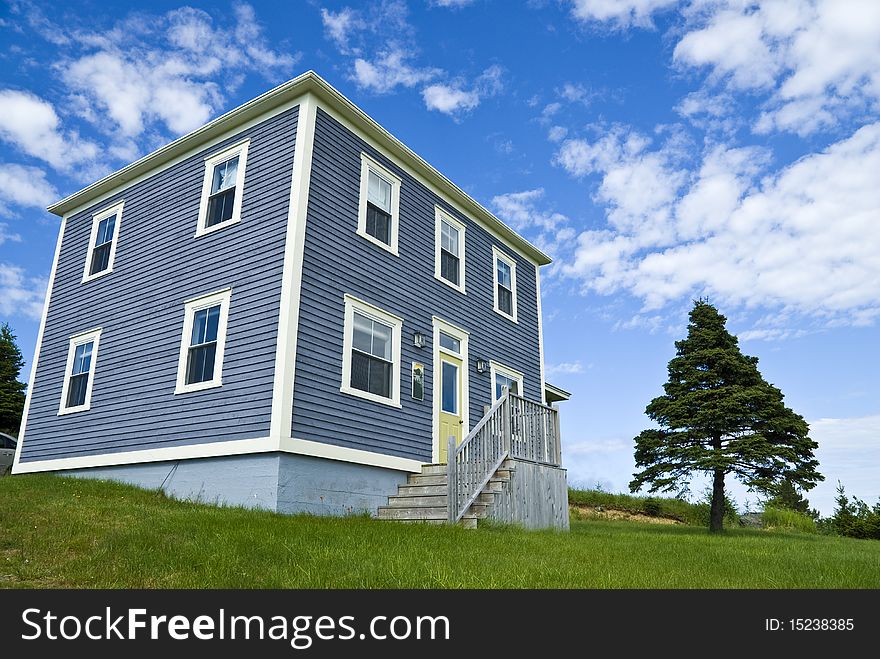 A traditional clapboard home with dramatic blue sky. A traditional clapboard home with dramatic blue sky.