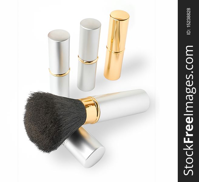 Golden and silver cosmetics set of brush and lipsticks.