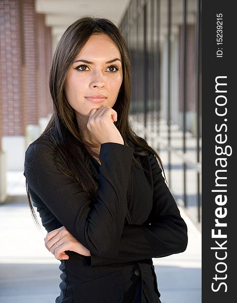 Attractive businesswoman thinking in front of an office building