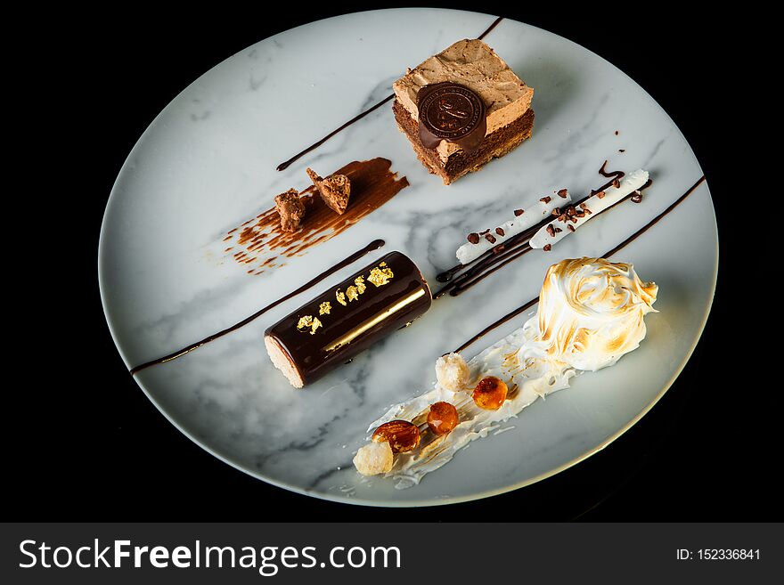 top view of delightful chocolate and white cream mousse dessert served on round plate on black background. top view of delightful chocolate and white cream mousse dessert served on round plate on black background