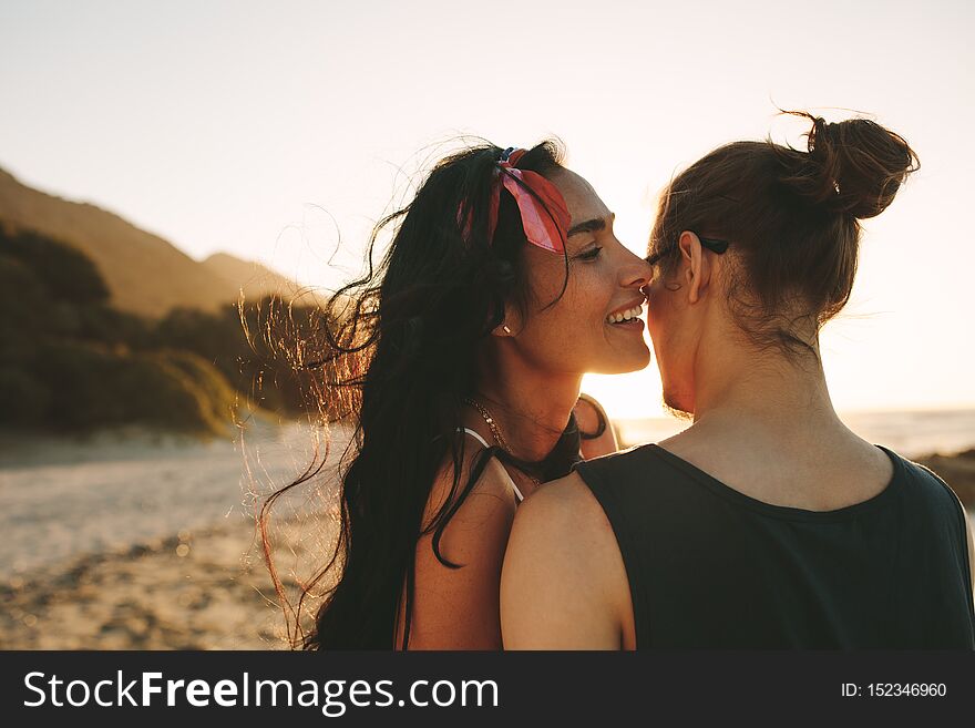 Woman whispering loving words in ear on her boyfriend. Beautiful couple spending time together on their summer vacation. Woman whispering loving words in ear on her boyfriend. Beautiful couple spending time together on their summer vacation