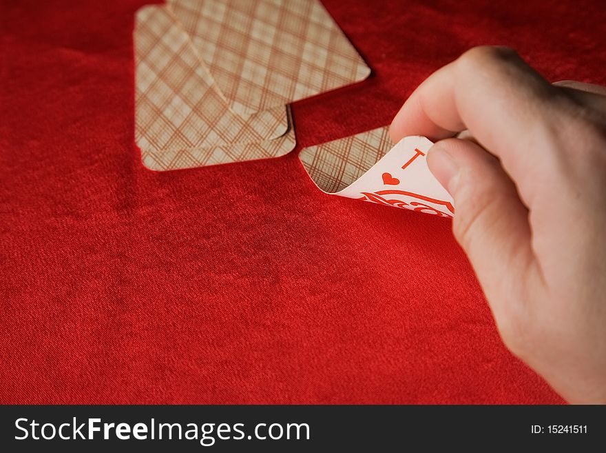 Player hold poker cards. The vintage poker cards on red table
