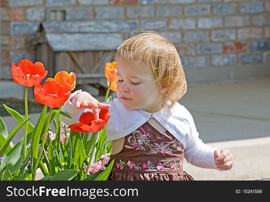 Little Girl Sitting Outside Enjoying Flowers. Little Girl Sitting Outside Enjoying Flowers