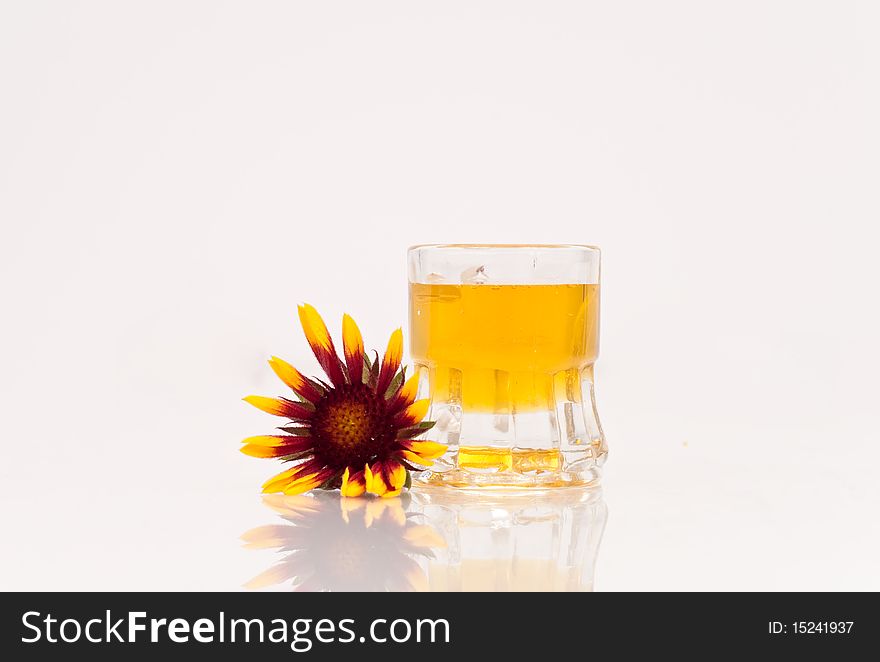 A tiny mug of honey with a red and yellow flower. A tiny mug of honey with a red and yellow flower