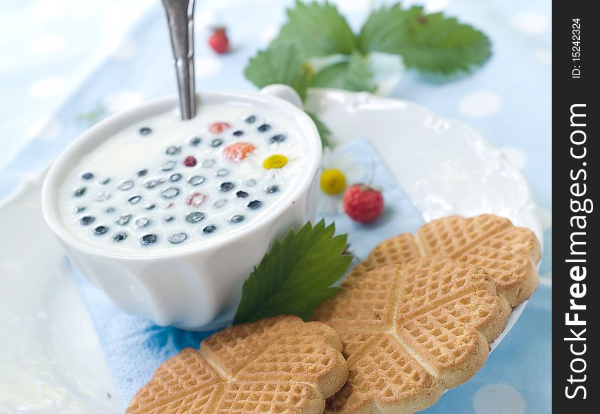 Cup of milk with cookies and berries for breakfast. Cup of milk with cookies and berries for breakfast