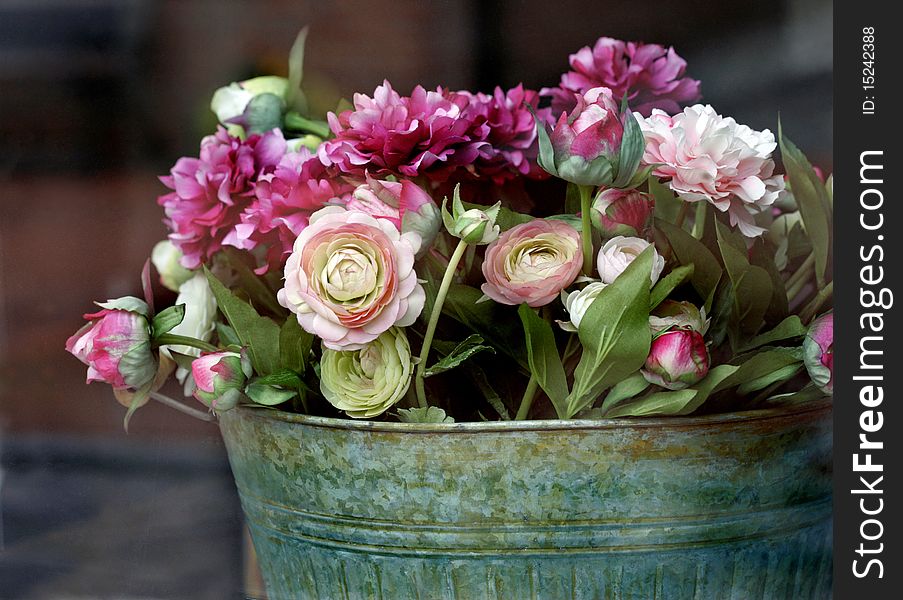 Colorful flowers in antique metal pot.