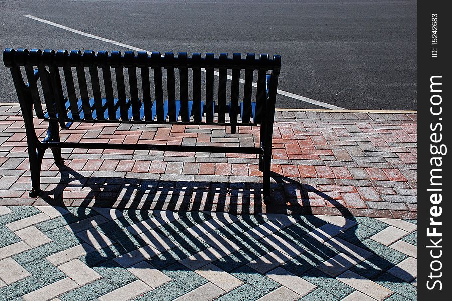 Empty city bench withlong shadow taken in early morning light