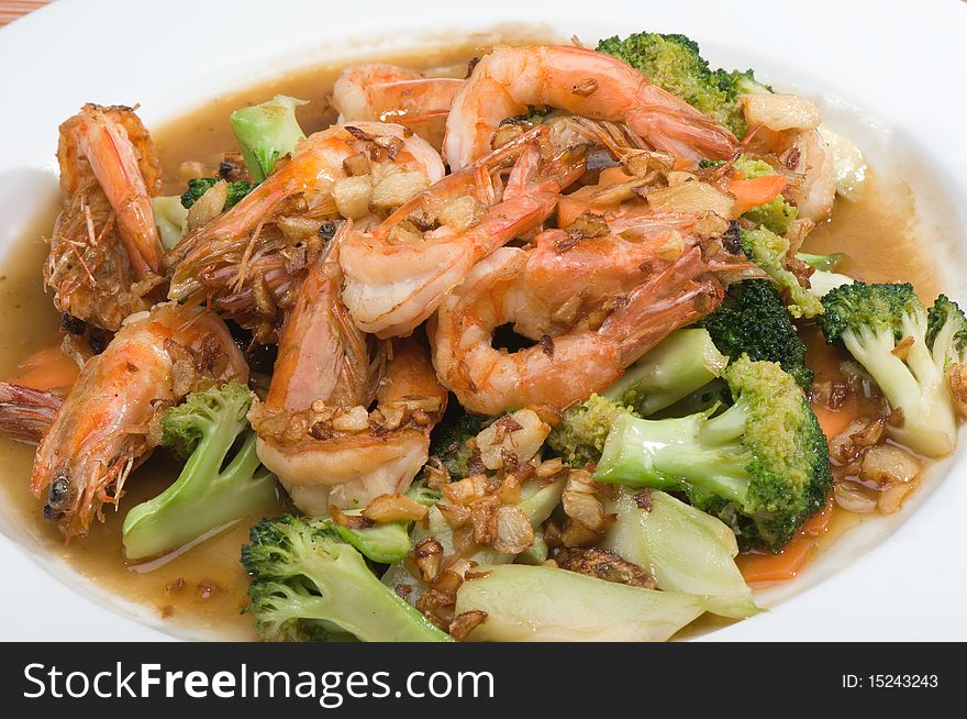 Fried shrimp and broccoli on white plate